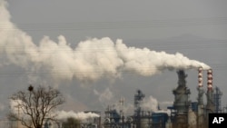 FILE - Smoke and steam rise from a coal processing plant that produces carbon black, an ingredient in steel manufacturing, in Hejin in central China's Shanxi Province, Nov. 28, 2019. 