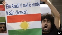 Seorang Kurdi dalam sebuah protes anti Presiden Suriah Assad di depan Kedubes Suriah di Lebanon (23/10/2011). Spanduk yang dibawanya berbunyi "Kami ingin kebebasan dan hak untuk orang Kurdi di Suriah".