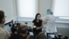 Journalists film as a woman gets injected with Sputnik-V vaccine against the coronavirus disease at a clinic in Moscow, Russia, Dec. 5, 2020.