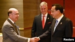 លោក Wilbur Ross ​រដ្ឋមន្ត្រី​ពាណិជ្ជកម្ម​អាមេរិក​ចាប់​ដៃ​ជាមួយ​នឹង​លោក Li Keqiang ​នាយករដ្ឋមន្ត្រី​ចិន​នៅ​ពេល​ចូលរួម​ក្នុង​កិច្ចប្រជុំ​ទ្វេភាគី ស្រប​ពេល​នៃ​កិច្ចប្រជុំ​កំពូល​អាស៊ាន​លើក​ទី៣៥ នៅ​ក្នុង​ក្រុង​បាងកក ប្រទេស​ថៃ កាលពី​ថ្ងៃទី៤ ខែវិច្ឆិកា ឆ្នាំ២០១៩។
