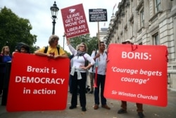 FILE - Pro-Brexit and anti-Brexit protesters with placards stand together at Westminster in London, Britain, Sept. 3, 2019.