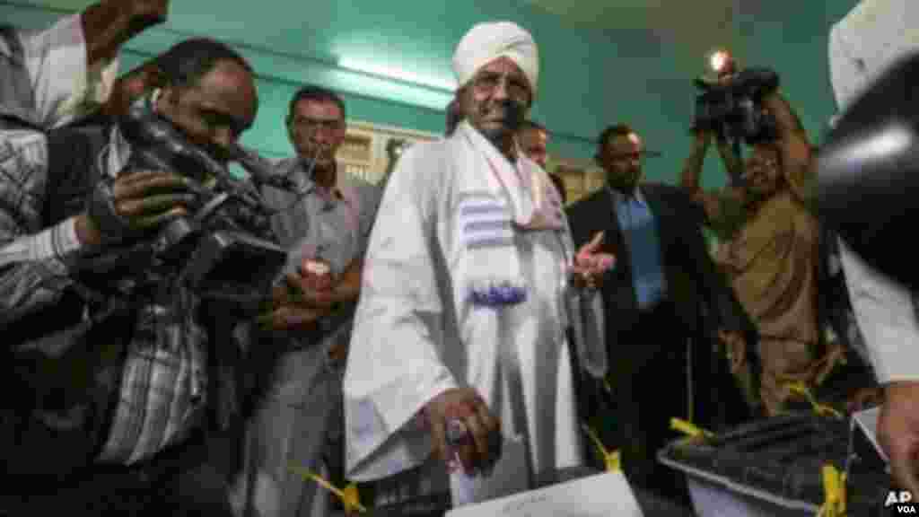 Le président Omar Hassan el-Béchir du Soudan place son bulletin de vote dans l’urne lors des élections à Khartoum, le 13 avril 2015.