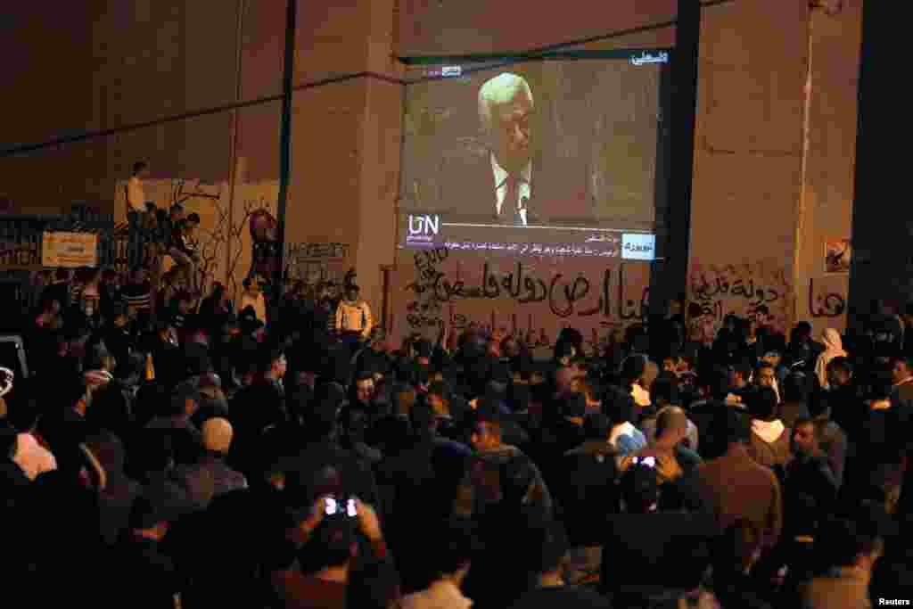 Palestinians rally while Palestinian President Mahmoud Abbas's speech is projected on Israel's controversial barrier in the occupied West Bank city of Bethlehem, November 29, 2012.