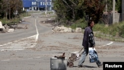 A man with a cart walks in a street in rebel-controlled Donetsk, Ukraine, July 18, 2015.