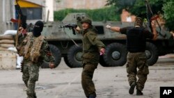 Separatis pro-Rusia bergembira setelah merebut 1 unit kendaraan militer pasukan Ukraina di Donetsk (foto: dok).