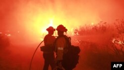 Los bomberos del Departamento de Bomberos de Los Ángeles (LAFD) y otros bomberos responden al Post Fire mientras arde en el Área de Recreación Vehicular Estatal de Hungry Valley en Lebec, California, el 16 de junio de 2024. 