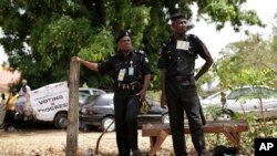 Deux policiers nigérians surveillent un quartier lors d'une journée de vote à Kaduna, le 28 mars 2015.