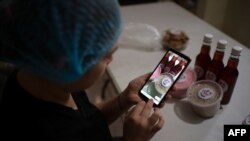  En la foto de archivo la productora salvadoreña de comerciales publicitarios Danella Nativi toma fotos de algunos de los productos que vende a través de las redes sociales junto a su esposo, luego de perder ambos sus trabajos.