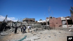 Warga di Sana'a, Yaman, memeriksa kerusakan akibat serangan udara yang dipimpin koalisi Saudi (27/2). (AP/Hani Mohammed)