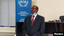 Paul Rusesabagina, the man who was hailed a hero in a Hollywood movie about Rwanda's 1994 genocide, is paraded in handcuffs in front of media at the headquarters of Rwanda's Investigation Bureau, in Kigali, Aug. 31, 2020.