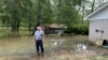 Miguel Flores se encuentra en su patio trasero inundado afuera de su casa en el vecindario de Kingwood, en el noreste de Houston, Texas, EEUU, el sábado 4 de mayo de 2024. (Foto AP/Juan Lozano)