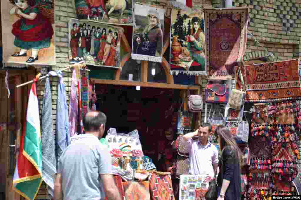 Erbil Kalesi’nin altında kültürel motiflerin ve önemli şahsiyetlerin portrelerinin olduğu ürünler satan bir dükkan.
