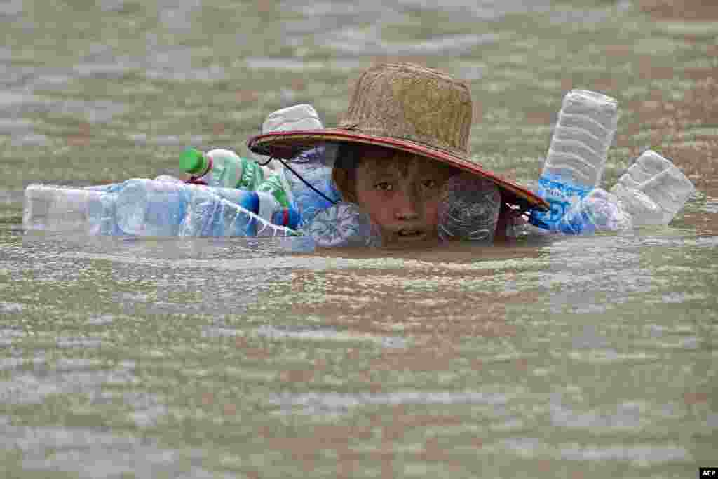 A flood-affected resident swims in floodwaters at Kyaut Ye village near the Hinthada town in Myanmar's Irrawaddy region, Aug. 11, 2015.