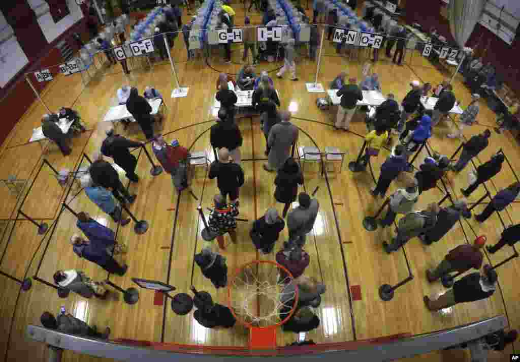 Voters wait in line in the gymnasium at Brunswick Junior High School to receive their ballots for the midterm election in Brunswick, Maine, Nov. 6, 2018.