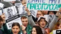 Para pengunjuk rasa membawa foto-foto para demonstran yang ditahan dan poster bertuliskan slogan-slogan "Beri kami hak untuk memilih" dalam unjuk rasa di Moskow, Rusia, 10 Agustus 2019. (Foto: AP)