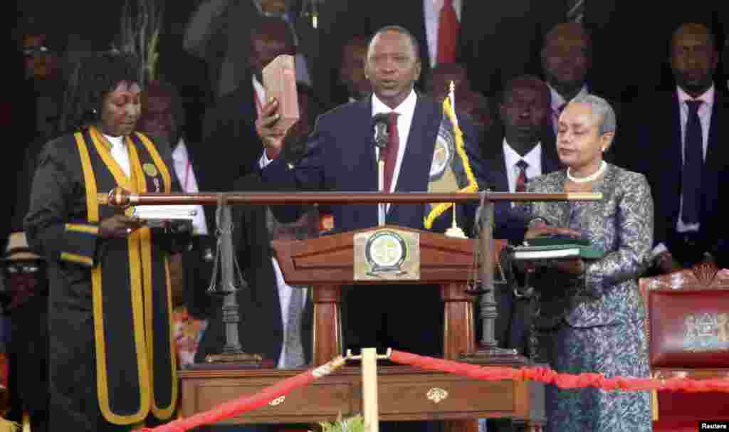 Rais wa Kenya Uhuru Kenyatta akila kiapu huku mkewe Margaret akishikilia Biblia wakati wa sherehe rasmi kwenye uwanja wa michezo wa Kasarani Nairobi, Aprili 9, 2013.