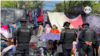 Policías nicaragüenses custodian al grupo de migrantes en la frontera con Costa Rica.