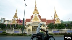 A man rides his motorbike in front of the National Assembly complex on May 02, 2018. (Aun Chhengpor/VOA Khmer)