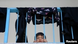 Un niño palestino que huyó de su hogar en la Franja de Gaza observa desde el interior de una escuela de Naciones Unidas donde está refugiado en la ciudad de Gaza el 19 de mayo de 2021.