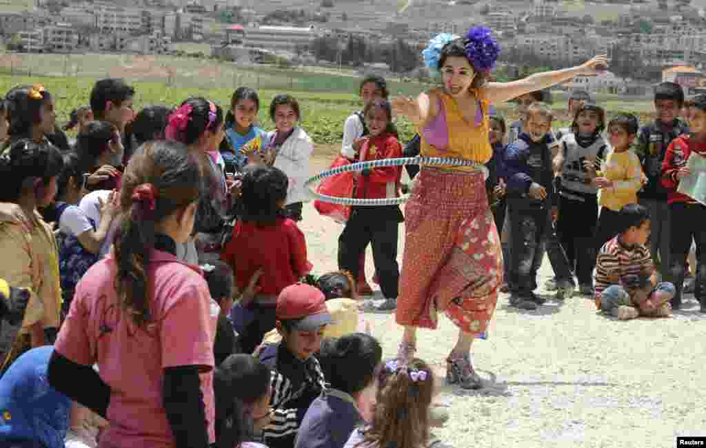 Seorang anggota klub sirkus &#39;Badut Tanpa Batas&#39; menghibur anak-anak pengungsi Suriah di Jab Janine, Lembah Bekaa barat.