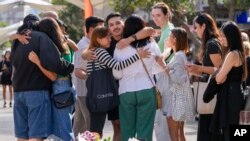 A group of people react after placing flowers as a tribute near a crime scene at Bondi Junction in Sydney, April 15, 2024, after several people were stabbed to death at a shopping on April 13. 