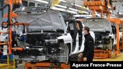 FILE - GMC Hummer EVs are seen on an assembly line at he General Motors Factory ZERO electric vehicle assembly plant in Detroit, Michigan, Nov. 17, 2021.