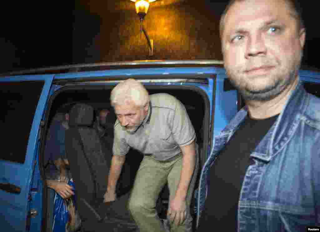 A just-released member of OSCE Special Monitoring Mission in Ukraine gets out of a vehicle next to Alexander Borodai, prime minister of the self-proclaimed Donetsk People's Republic, Donetsk, Ukraine, June 26, 2014.