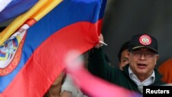 ARCHIVO: El presidente de Colombia, Gustavo Petro, ondea una bandera mientras la gente asiste a una marcha en apoyo de las reformas en los sectores de salud, jubilación, empleo y prisiones propuestas por su gobierno, en Bogotá, Colombia, el 1 de mayo de 2024.