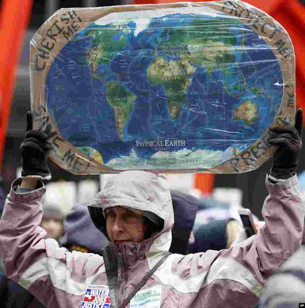 A demonstrator holds a sign during "100 Days of Failure" protest and march in Chicago, April 29, 2017. Thousands of people across the U.S. are marking President Donald Trump's hundredth day in office by marching in protest of his environmental policies.