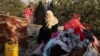 A Palestinian woman reacts as she sits at the remains of a house destroyed in an Israeli air strike in the southern Gaza Strip, Nov. 13, 2019. 