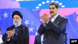 Los presidentes de Irán y Venezuela, Ebrahim Raise (izquierda) y Nicolás Maduro, participan en un acto oficial en el teatro Teresa Carreño de Caracas, el 13 de junio de 2023, en esta fotografía divulgada por el Palacio de Miraflores.