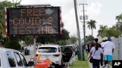 ARCHIVO - Las personas hacen fila para para realizarse las pruebas de coronavirus en Opa-locka, estado de Florida en junio de 2019.