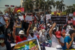 Demonstrators display placards during a protest close to Indonesian Embassy in Yangon, Myanmar, Feb. 23, 2021.