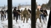 A military instructor teaches civilians holding wooden replicas of Kalashnikov rifles, during a training session at an abandoned factory in the Ukrainian capital of Kyiv on Jan. 30, 2022.