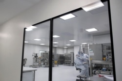FILE - Laboratory technicians work at the mAbxience biopharmaceutical company on an experimental coronavirus vaccine developed by Oxford University and the laboratory AstraZeneca in Garin, Argentina, Aug. 14, 2020.