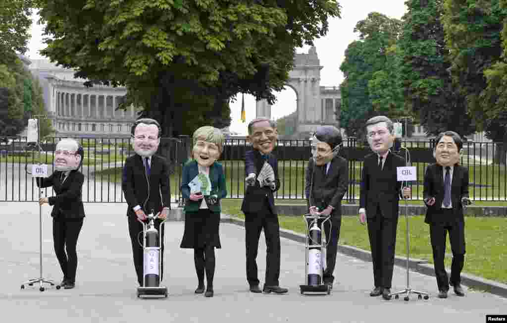 Oxfam's activists wear masks depicting leaders of the countries members of the G7, (L-R) French President Francois Hollande, British Prime Minister David Cameron, German Chancellor Angela Merkel, U.S. President Barack Obama, Italian Prime Minister Matteo Renzi, Canadian Prime Minister Stephen Harper and Japanase Prime Minister Shinzo Abe, during a protest called "Energy dependency and wealth inquality" outside the European Council in Brussels, Belgium.