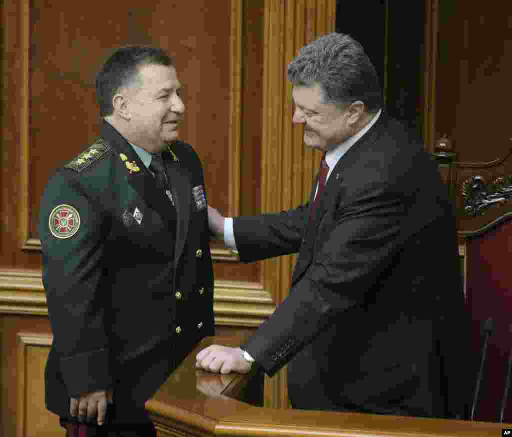 Ukrainian President Petro Poroshenko speaks with new Defense Minister Stepan Poltorak in parliament, Kyiv, Ukraine, Oct. 14, 2014.