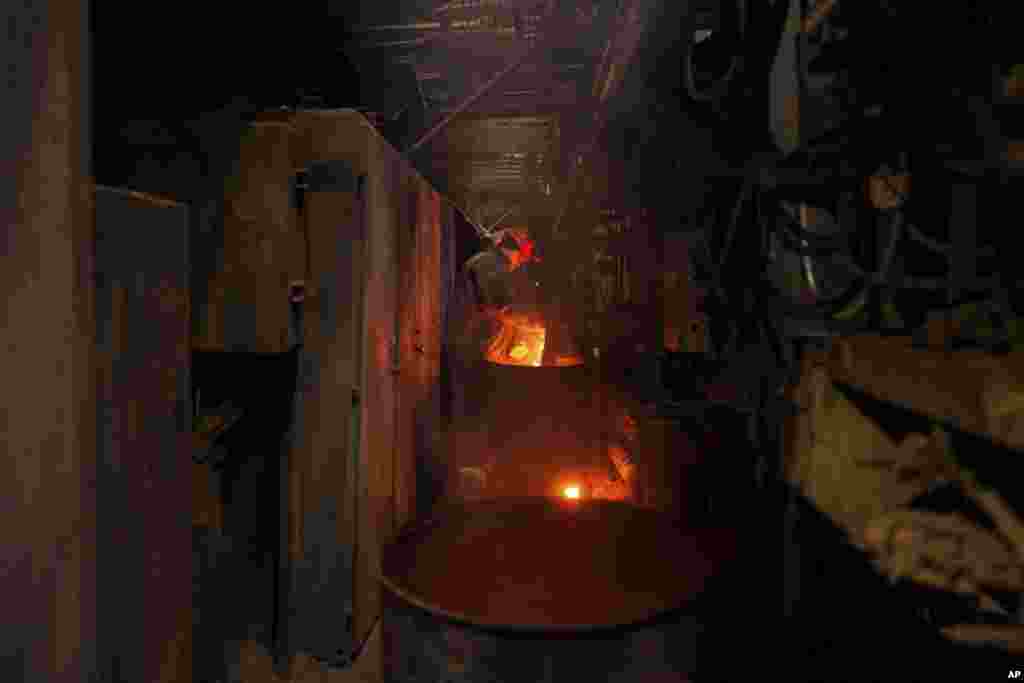Un trabajador arroja leña a una estufa para calentar las tuberías de la planta eléctrica de DTEK, el 28 de noviembre de 2024. 