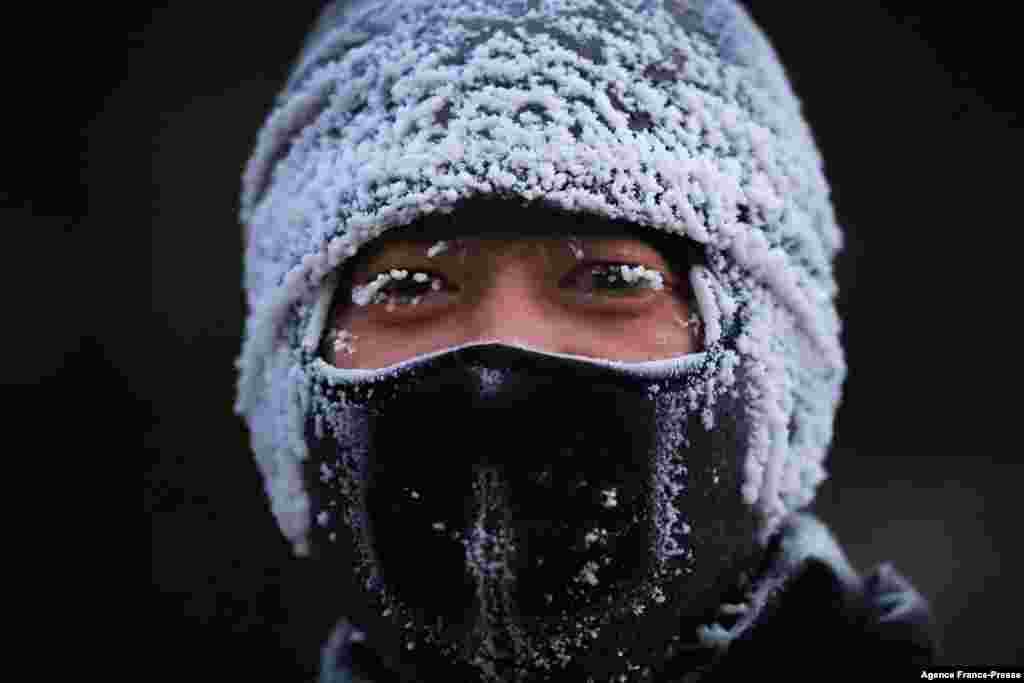 A man covered with ice is seen when the temperature drops down to -24°C (-11.2°F) in Shenyang in China's northeastern Liaoning province.
