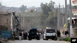 Security officials investigate the scene of a suicide car bomb attack, which killed and injured several people at the National Directorate of Security in Jalalabad, Afghanistan, February 24, 2013. 