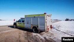 An emergency vehicle blocks the road to traffic the day after a bus carrying the Humboldt Broncos junior hockey team collided with a semitrailer nearby, near Tisdale, Saskatchewan, April 7, 2018. 