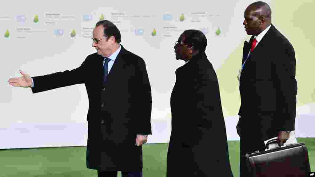 Shugaba Robert Mugabe Na Gaisawa Da Shugaba Kasar Faransa Francois Hollande Daga Hagu A Yayin Da Ya Isa Wurin Bude Taron Majalisar Dinkin Duniya Akan Dumamar Yanayi Na Duniya A Bourget Kusa Da Birnin Paris. Nuwamba 30, 2015. 