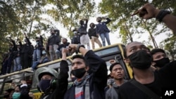 Indonesian students raise their fists and shout slogans during a protest against a controversial omnibus bill on job creation, in Tangerang Indonesia, Oct. 7, 2020.