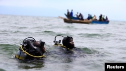 FILE -Members of the Uganda Police Marine Unit participate in rescue efforts after a boat carrying mostly Congolese refugees capsized in Lake Albert southwest of Uganda's capital, Kampala, March 23, 2014.
