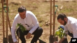 El canciller mexicano Marcelo Ebrard, a la izquierda, y el presidente de El Salvador, Nayib Bukele, plantan un árbol durante el lanzamiento del programa "Sembrando Vida" en San Luis Talpa, El Salvador, el viernes 19 de julio de 2019. 