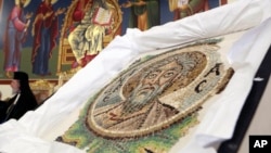 Cyprus' Archbishop Chrysostomos II is seen in the background next to the extremely rare 6th century mosaic depicting St. Andrew, during a ceremony of repatriation at the Archbishop in capital Nicosia, Cyprus, April 23, 2018.