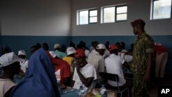 Atendidos por soldados y voluntarios de la Cruz Roja, los sobrevivientes del desafortunado viaje almuerzan en una escuela convertida en refugio, en la isla de Sal, Cabo Verde, el lunes 21 de agosto de 2023, una semana después de que su barco fuera encontrado perdido en el mar.