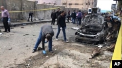 Investigators search the area after a bomb placed under a car exploded, in Alexandria, Egypt, March 24, 2018.
