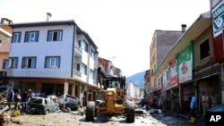 Workers clear mud from a street in Bozkurt town, Kastamonu province, Turkey, Aug. 14, 2021. The death toll from severe floods and mudslides in coastal Turkey was near 60, the country's emergency and disaster agency said.