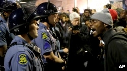 A protester yells at a Missouri State Police officer during a protest at the Ferguson, Missouri, police headquarters, Oct. 10, 2014.